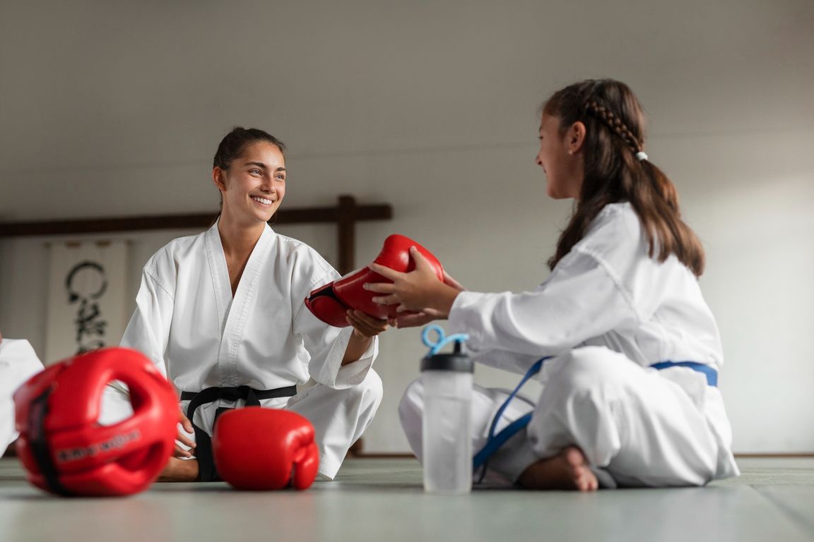Dos practicantes de karate preparando guantes de protección antes de entrenar